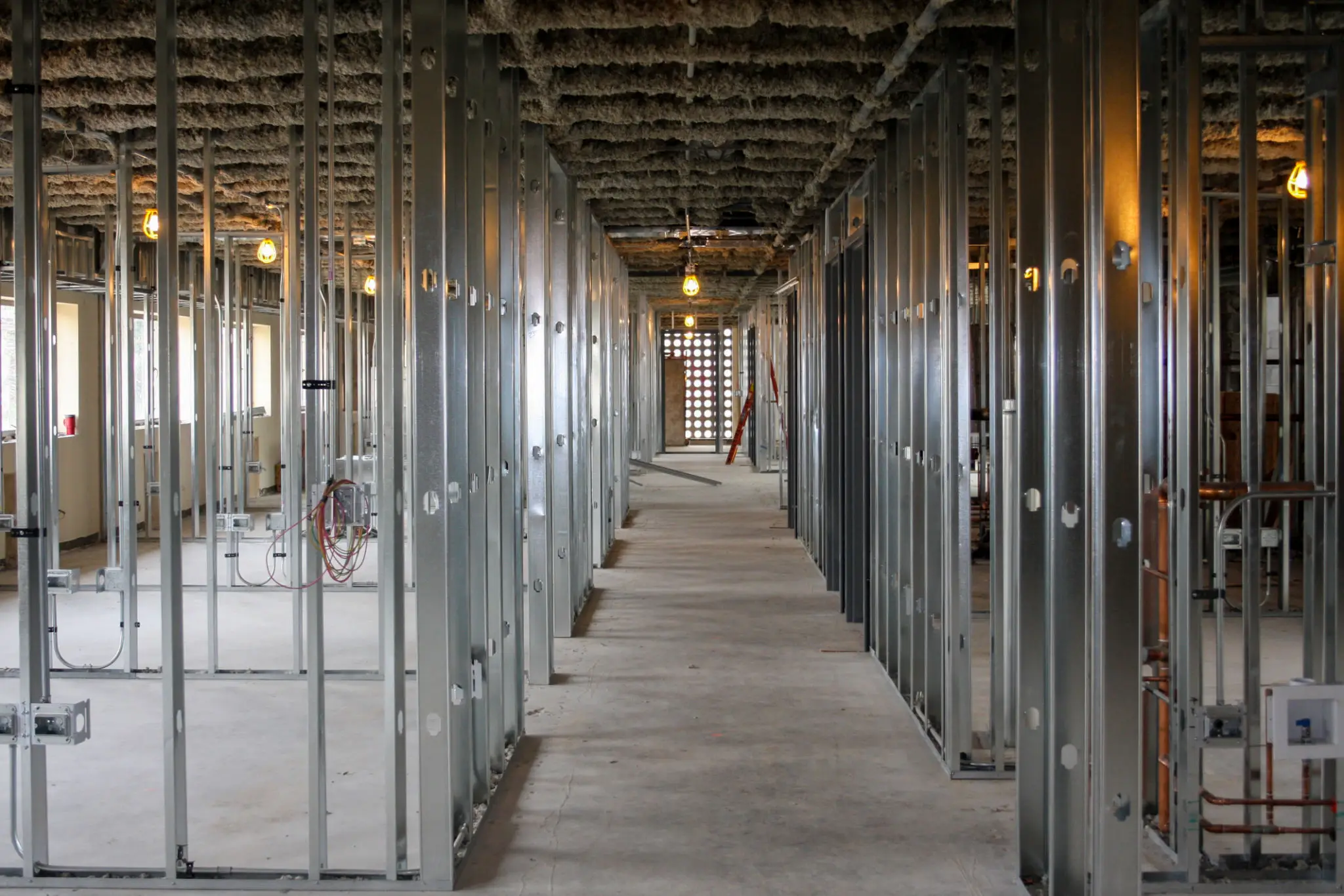 A long corridor in a building under construction with metal framing.